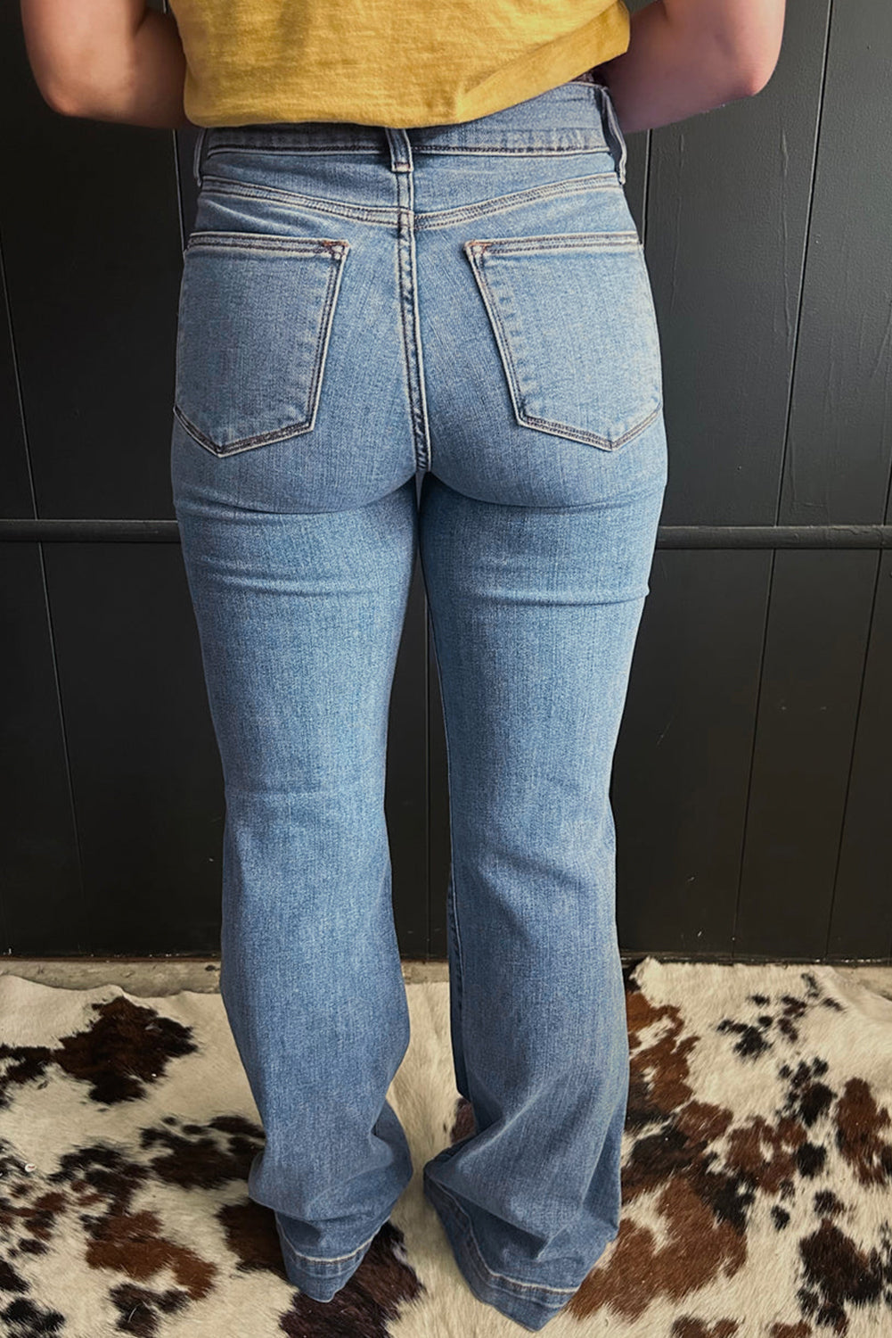 Jeans acampanados azul crepúsculo de cintura alta, con botones y ribete de vivo