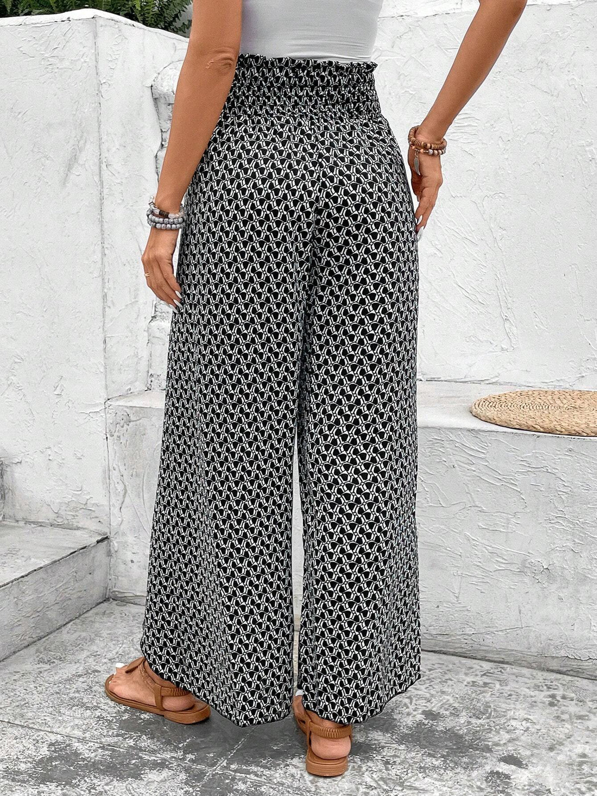 Pantalones negros de pierna ancha con estampado floral, fruncido y abertura lateral