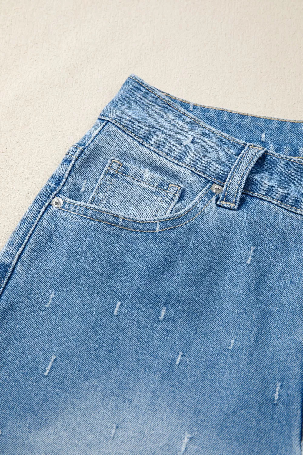 Jeans de control de abdomen con detalles desgastados y dobladillo sin rematar