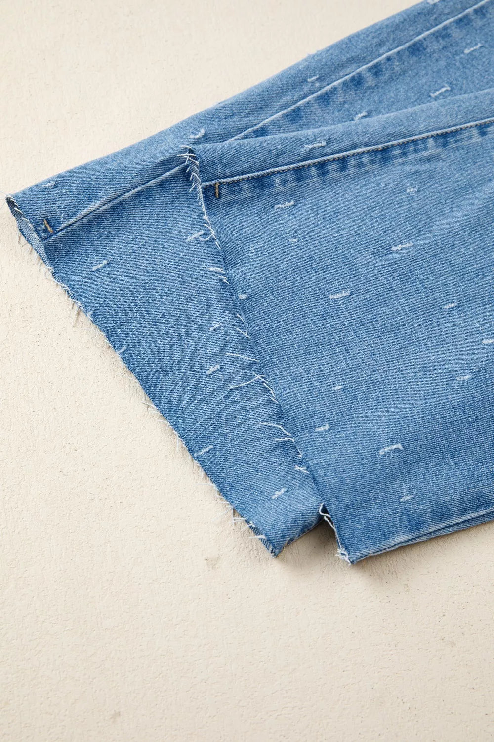 Jeans de control de abdomen con detalles desgastados y dobladillo sin rematar