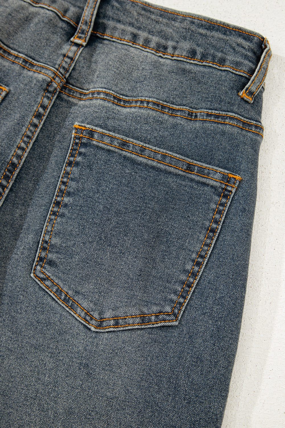 Jeans azul vela de tiro alto, pierna recta y diseño cruzado