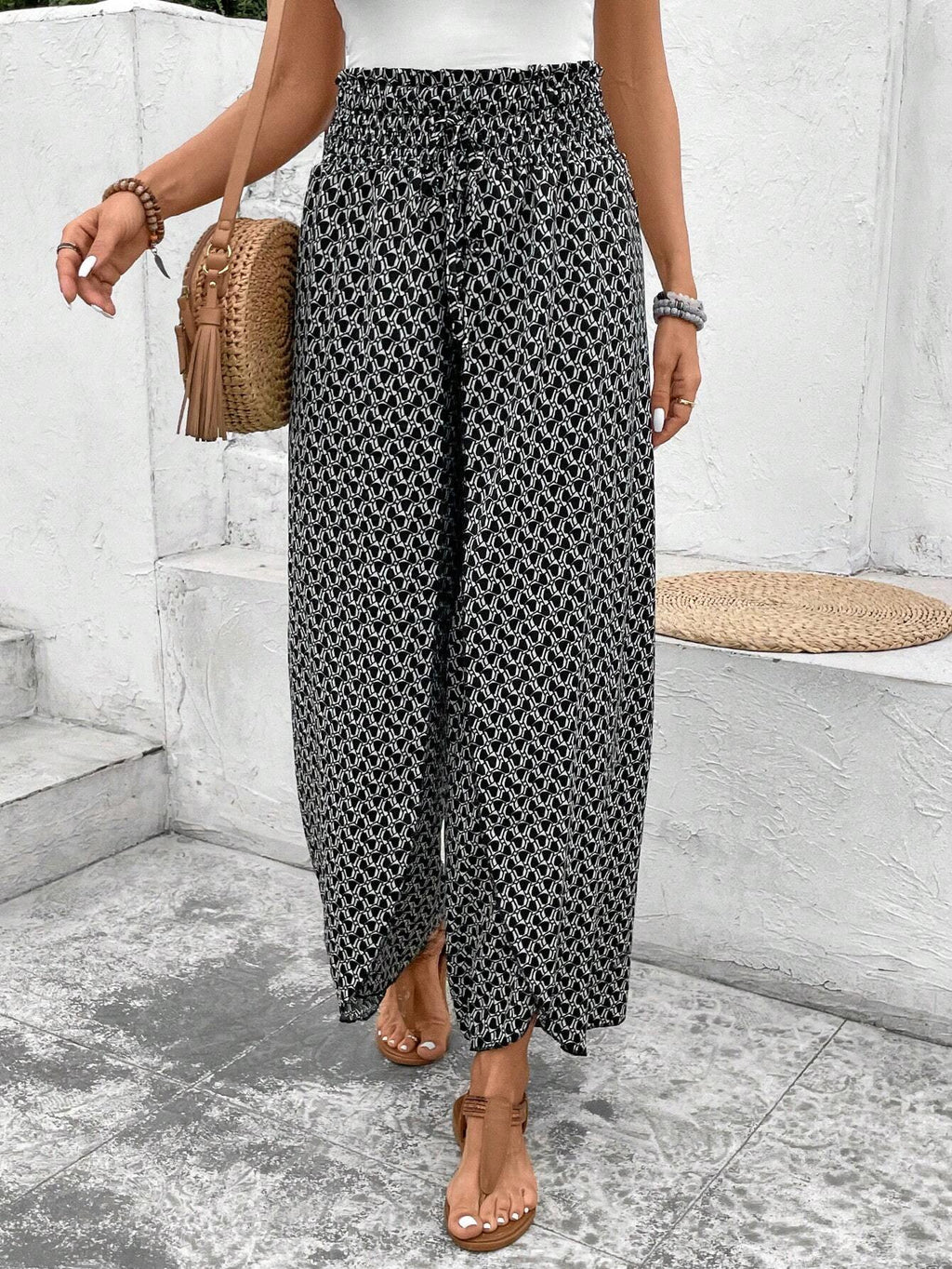 Pantalones negros de pierna ancha con estampado floral, fruncido y abertura lateral