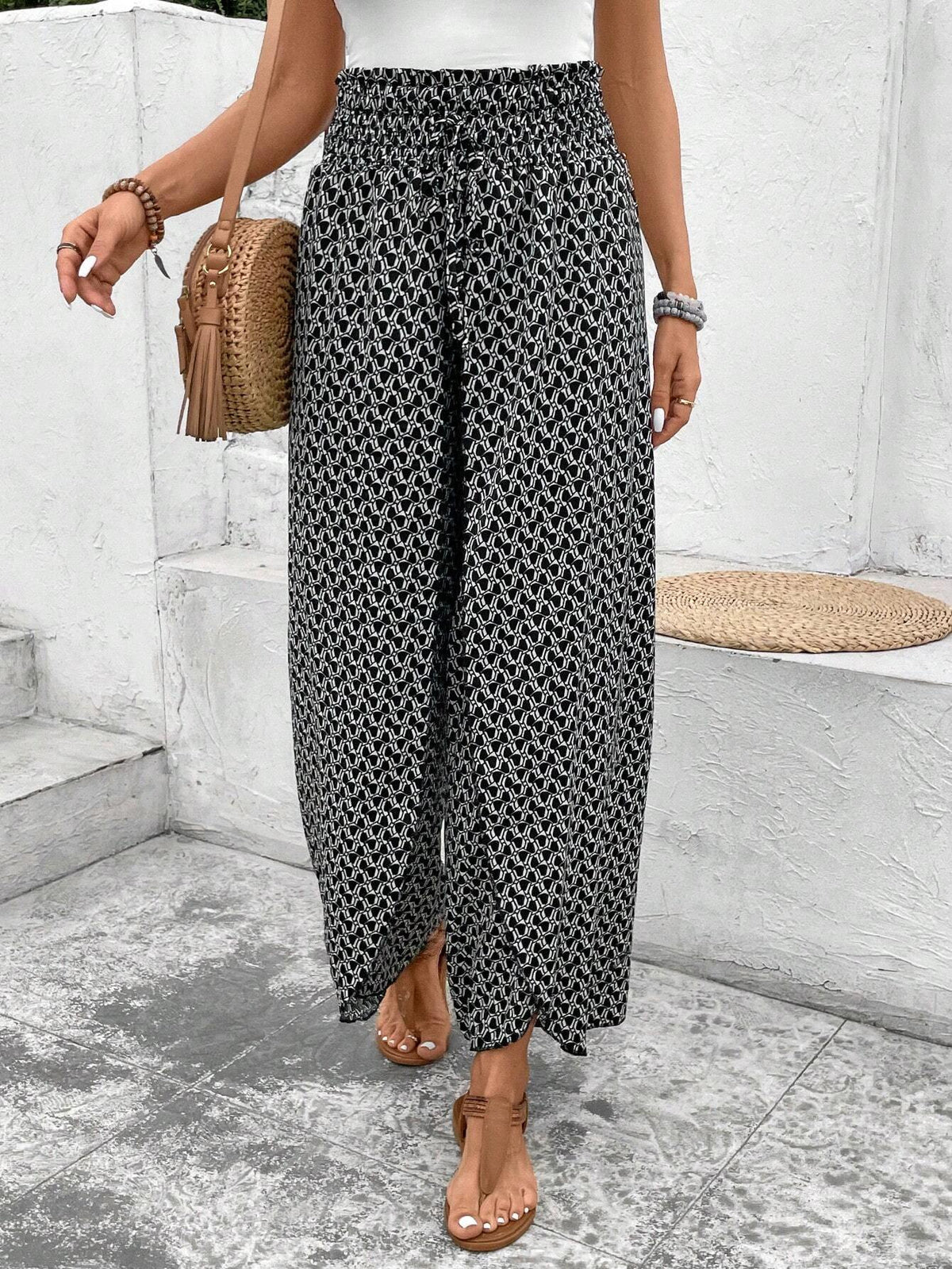 Pantalones negros de pierna ancha con estampado floral, fruncido y abertura lateral