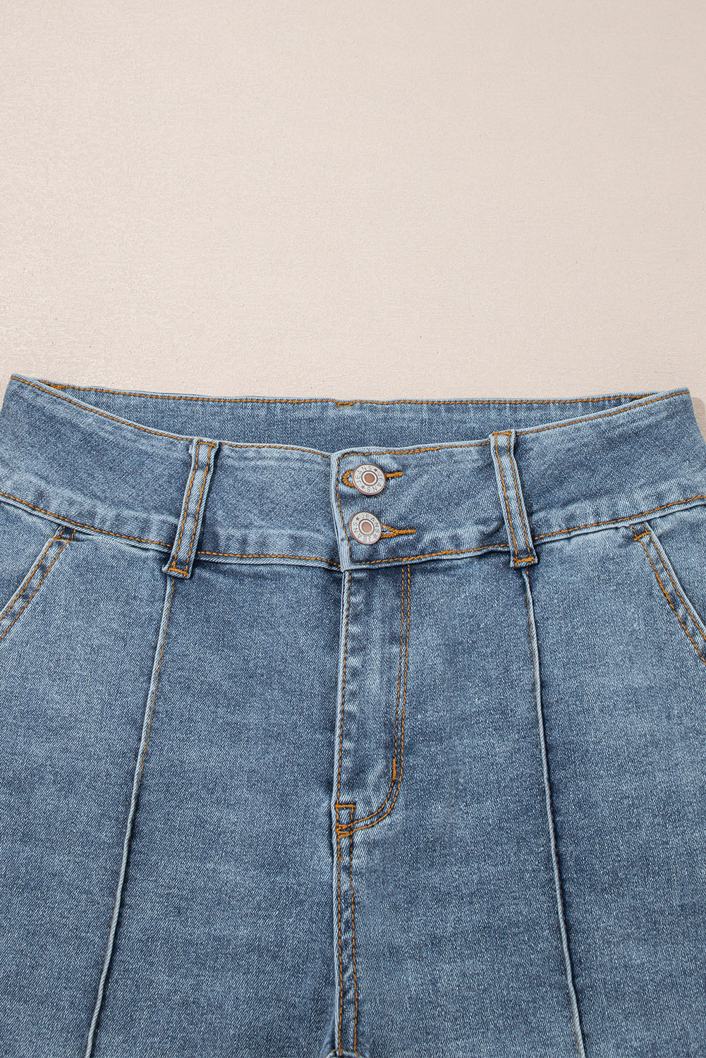 Jeans acampanados azul crepúsculo de cintura alta, con botones y ribete de vivo