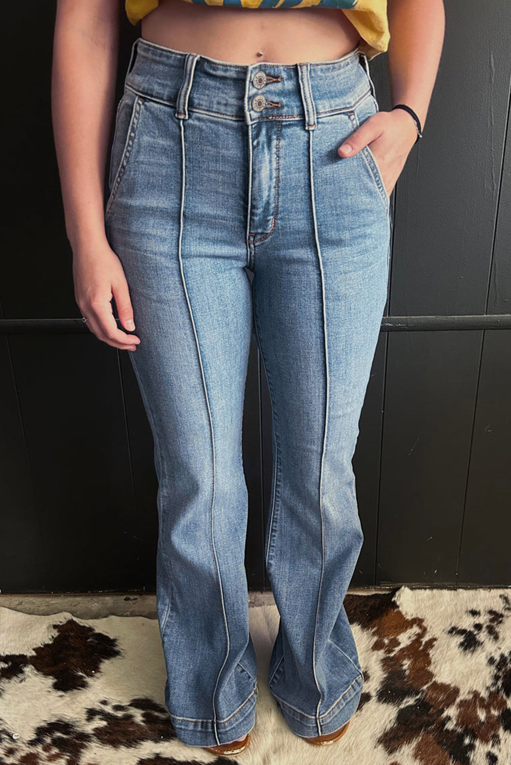 Jeans acampanados azul crepúsculo de cintura alta, con botones y ribete de vivo