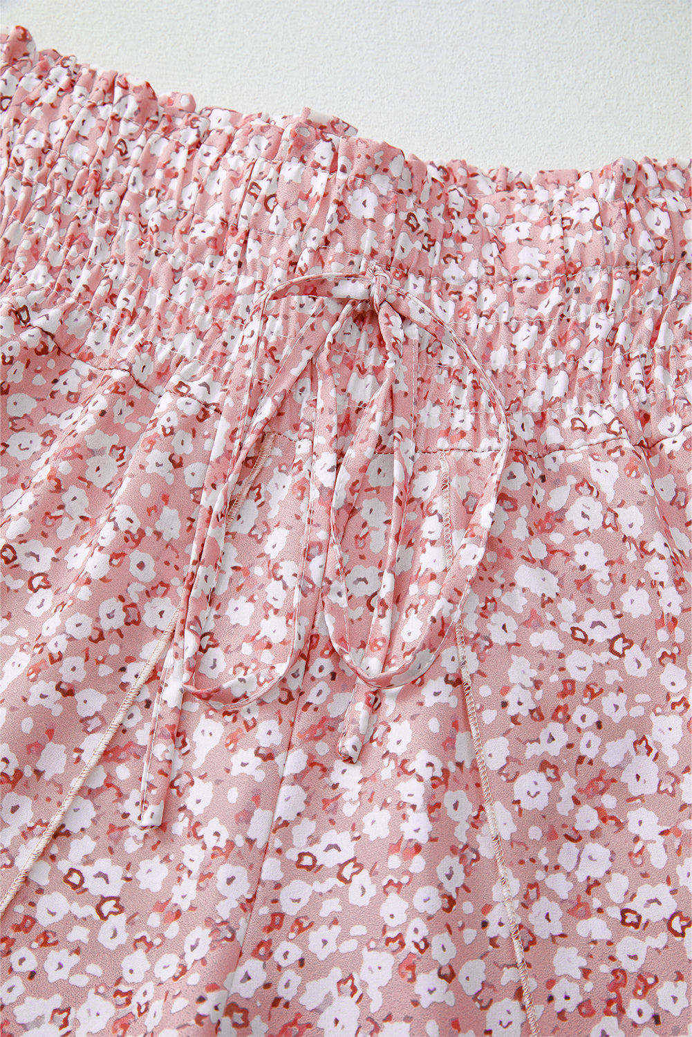 Pantalones negros de pierna ancha con estampado floral, fruncido y abertura lateral