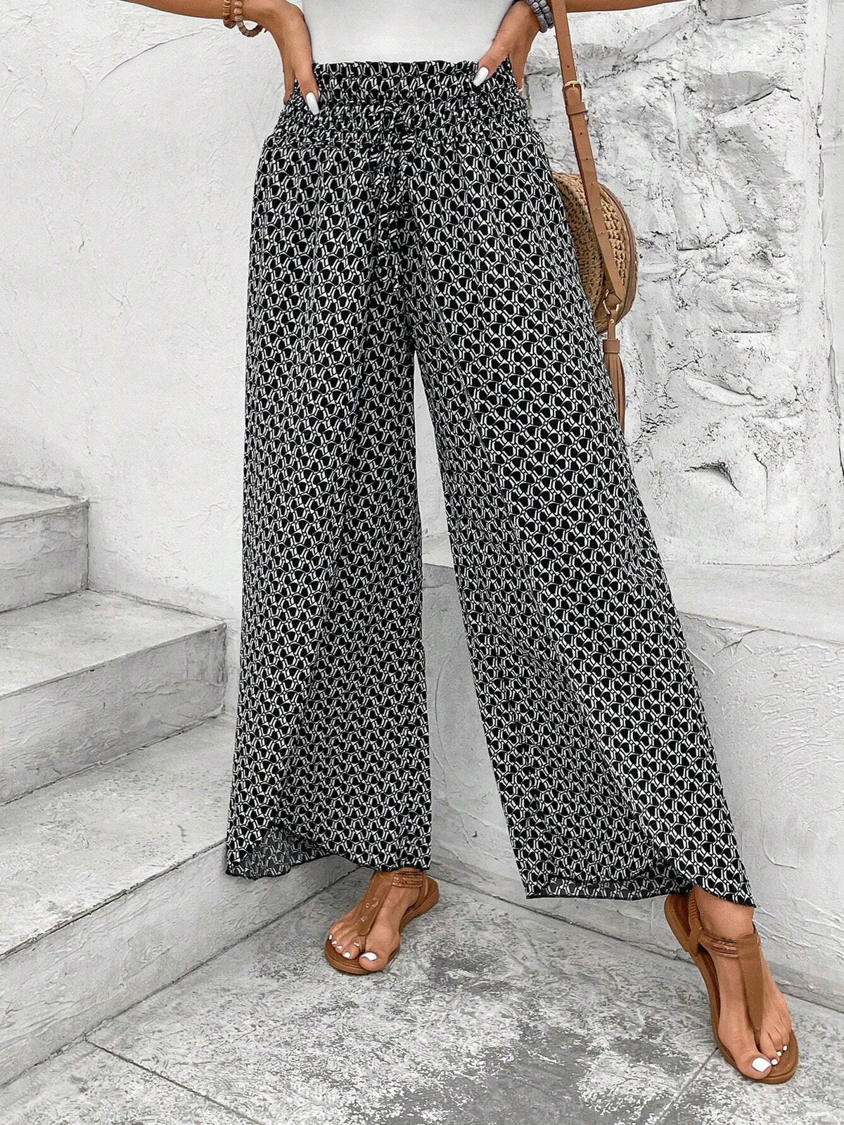 Pantalones negros de pierna ancha con estampado floral, fruncido y abertura lateral
