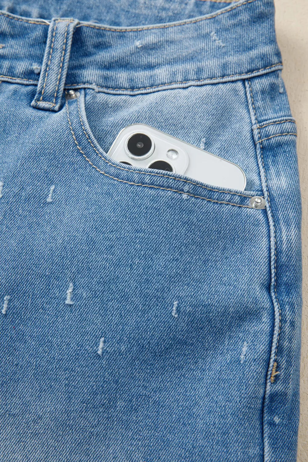 Jeans de control de abdomen con detalles desgastados y dobladillo sin rematar