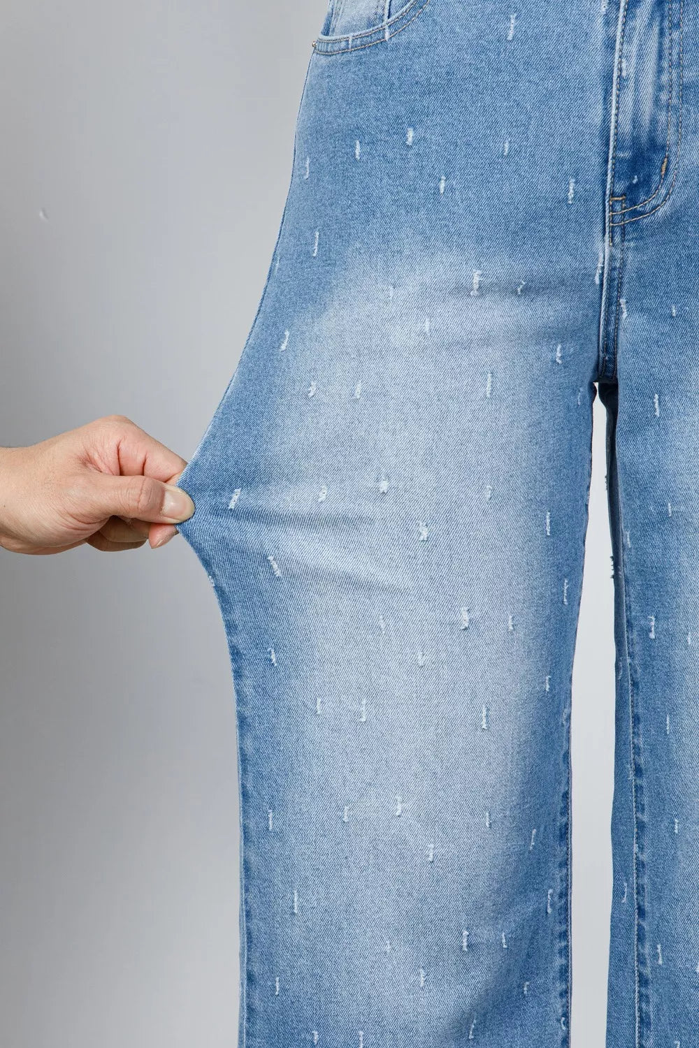Jeans de control de abdomen con detalles desgastados y dobladillo sin rematar