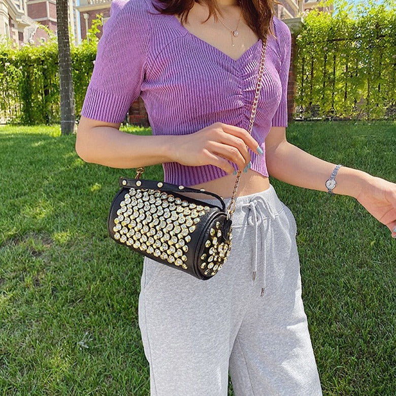 Bolso bandolera con eslogan, pedrería y tachuelas