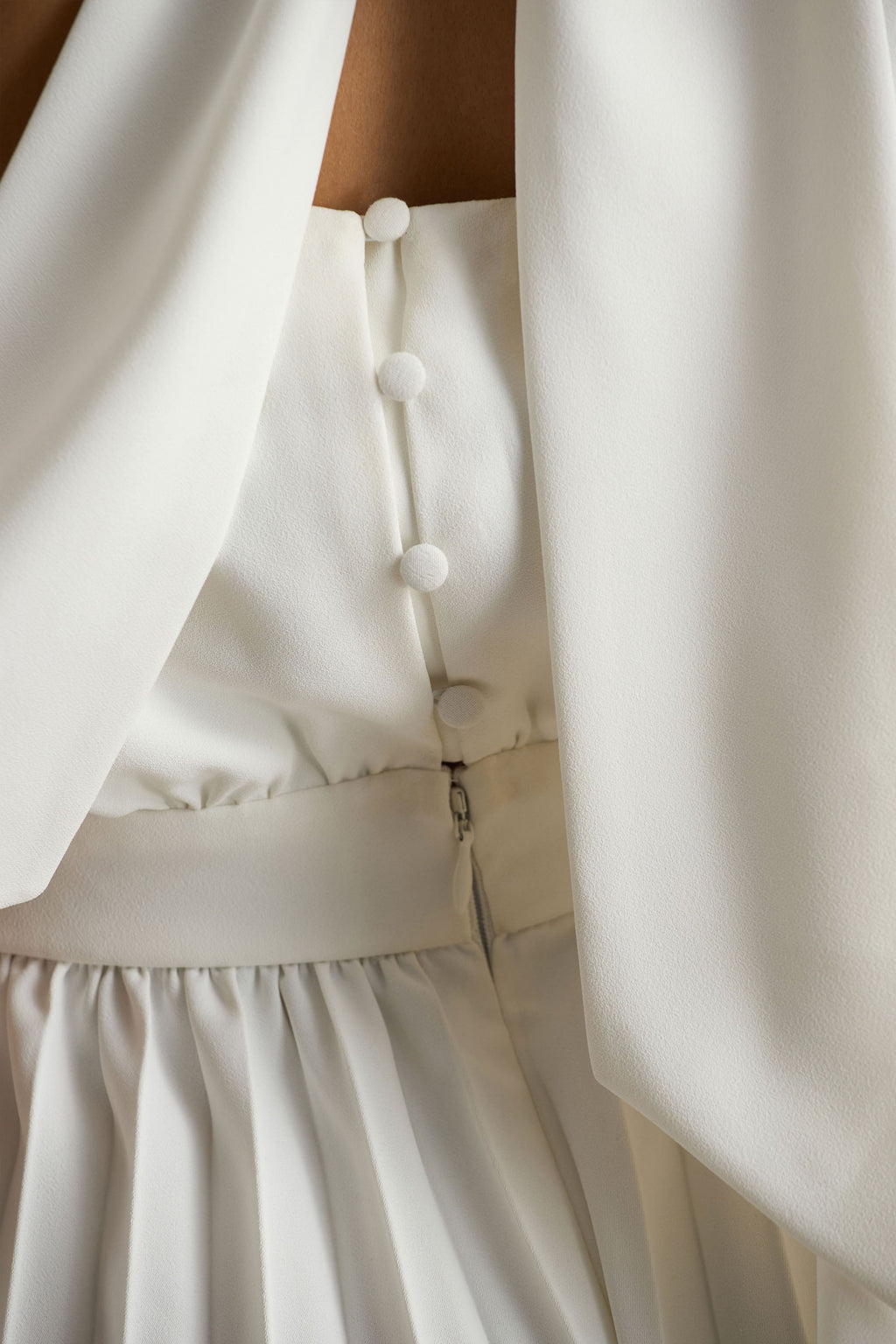 Paradise | Mono blanco con detalle de lazada en el cuello y manga tipo capa